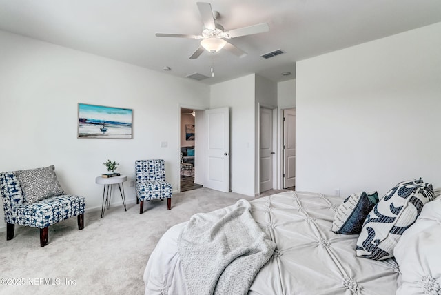 bedroom featuring a ceiling fan, visible vents, and light carpet