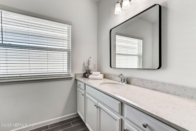 bathroom featuring wood finish floors, vanity, and baseboards