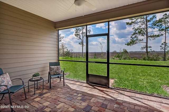 unfurnished sunroom with a ceiling fan