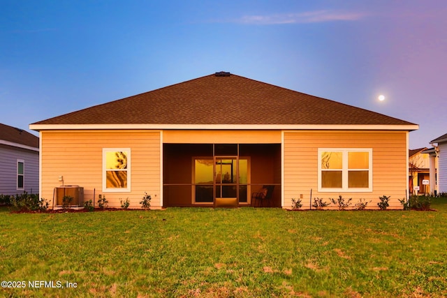 back of house featuring a yard, a sunroom, and central air condition unit