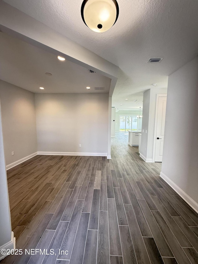 15 Wimbledon Way, Palm Coast, FL 32164 - unfurnished room with visible vents, baseboards, a textured ceiling, and dark wood-style flooring