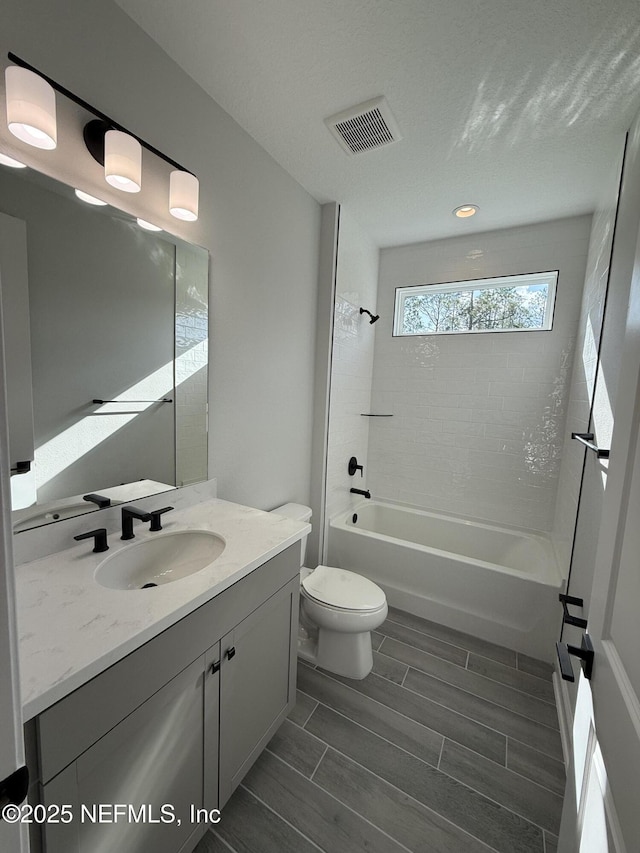 15 Wimbledon Way, Palm Coast, FL 32164 - bathroom with vanity, visible vents, wood finish floors, toilet, and shower / bathtub combination