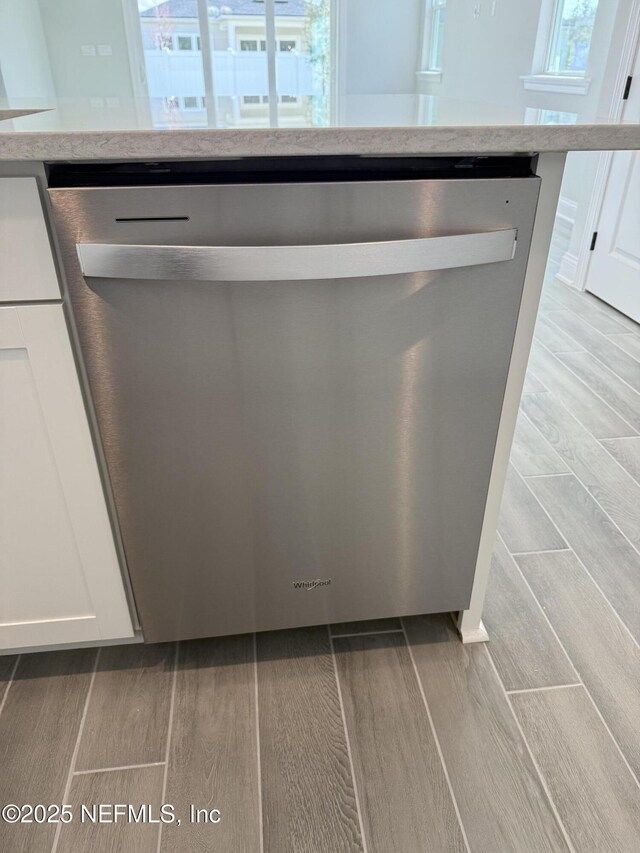 15 Wimbledon Way, Palm Coast, FL 32164 - details featuring dishwasher, light stone countertops, white cabinetry, and wood finish floors