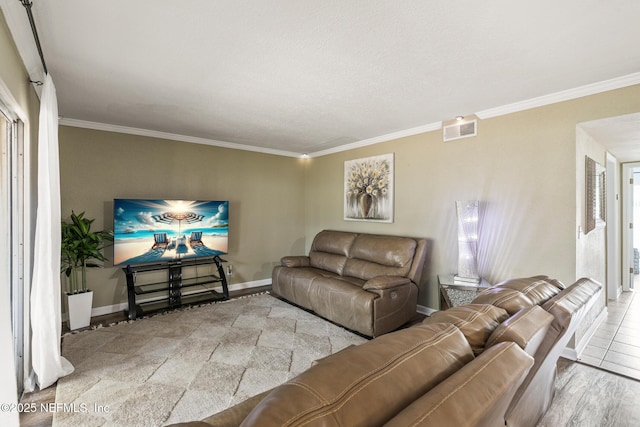 living room with crown molding, visible vents, and baseboards