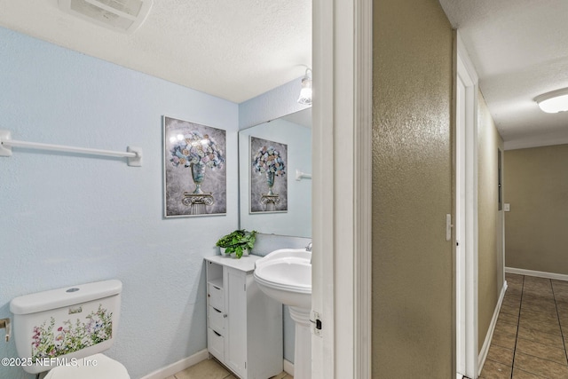 bathroom with visible vents, baseboards, toilet, tile patterned floors, and a textured ceiling