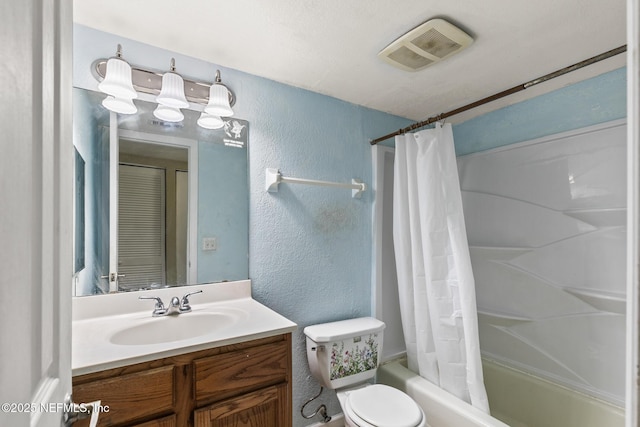 full bath featuring visible vents, a textured wall, vanity, and toilet