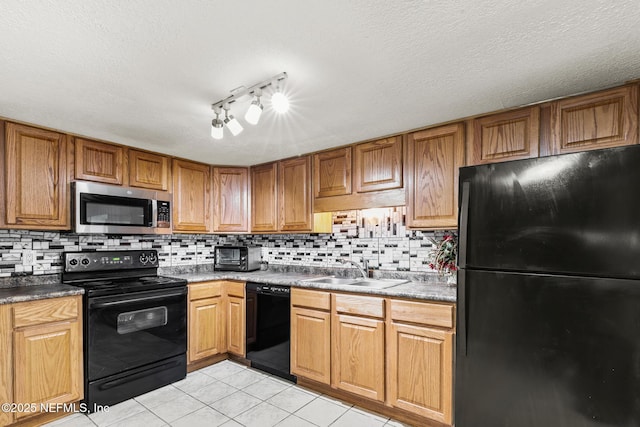 kitchen with light tile patterned flooring, a sink, black appliances, tasteful backsplash, and brown cabinetry