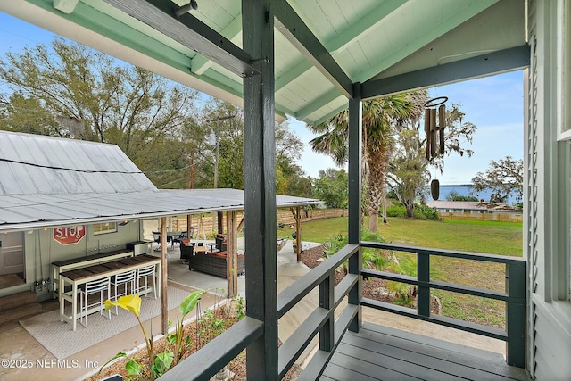 wooden deck featuring outdoor lounge area, a lawn, and a patio