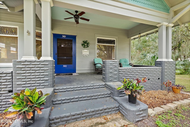 view of exterior entry featuring a porch and a ceiling fan