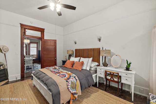 bedroom featuring a ceiling fan, baseboards, and wood finished floors