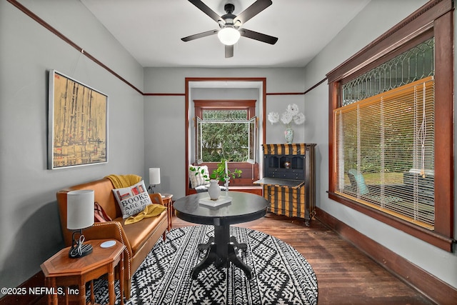 sitting room featuring wood finished floors, a ceiling fan, and baseboards