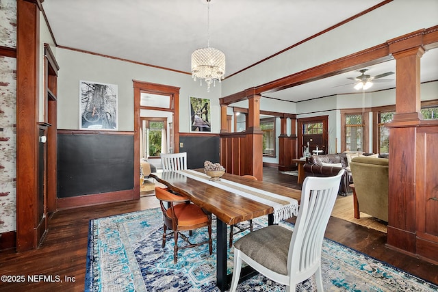 dining space featuring crown molding, wood-type flooring, decorative columns, and ceiling fan with notable chandelier