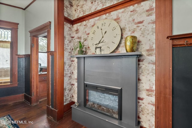 room details featuring baseboards, a glass covered fireplace, wood finished floors, and wallpapered walls