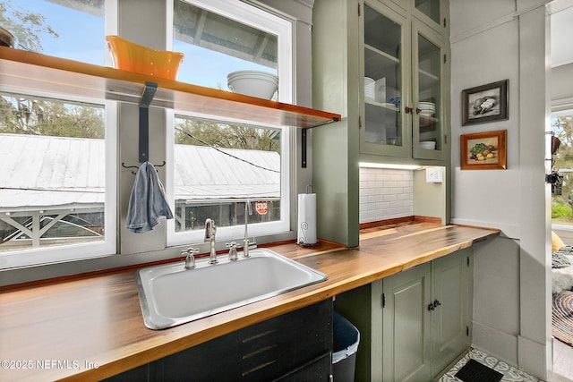 kitchen with plenty of natural light, a sink, backsplash, and wooden counters