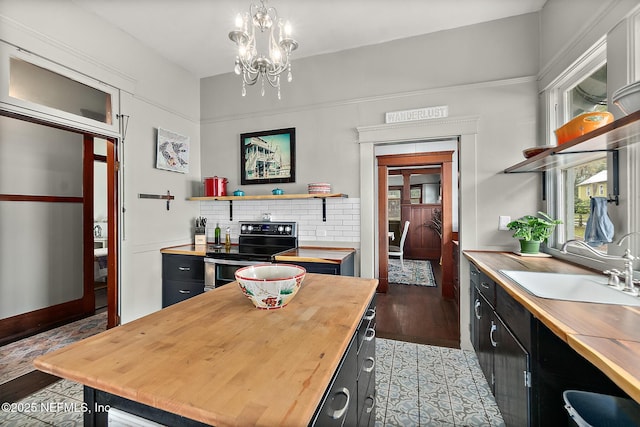 kitchen with open shelves, butcher block counters, electric range, a sink, and dark cabinetry