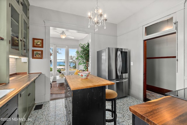 kitchen with ceiling fan with notable chandelier, wood counters, backsplash, smart refrigerator, and a kitchen bar