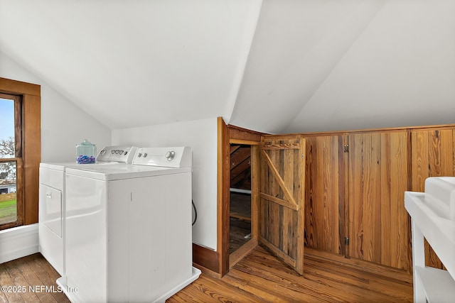 laundry room with laundry area, washing machine and clothes dryer, and wood finished floors