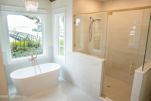 bathroom with independent shower and bath and a notable chandelier