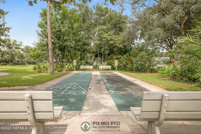 view of community featuring shuffleboard and a lawn