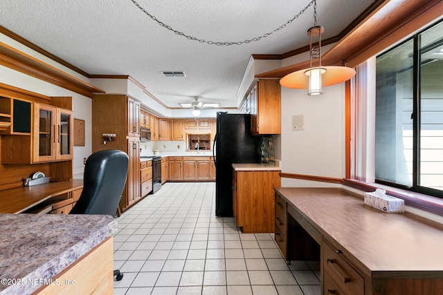 kitchen featuring visible vents, light countertops, built in study area, black appliances, and decorative light fixtures