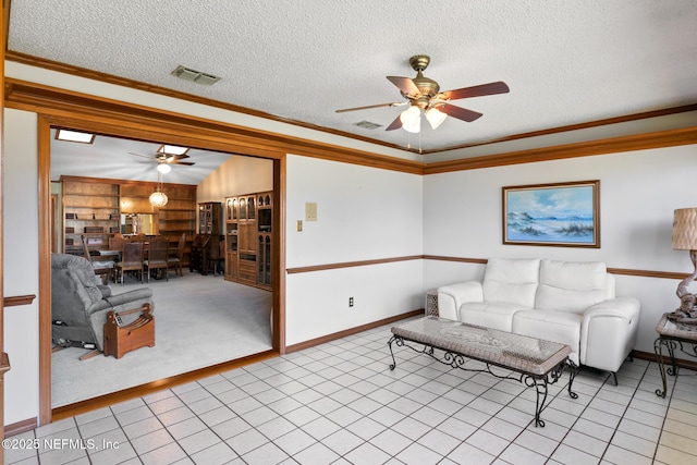 living room with visible vents, crown molding, and a textured ceiling