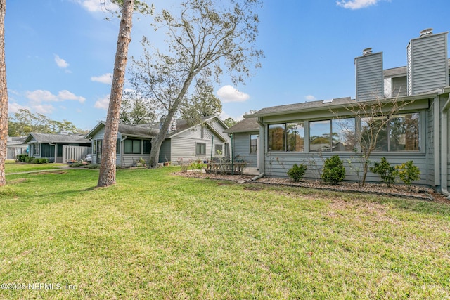 back of property featuring a lawn and a chimney