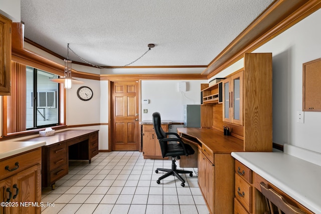 office area featuring a textured ceiling, ornamental molding, light tile patterned flooring, and built in study area