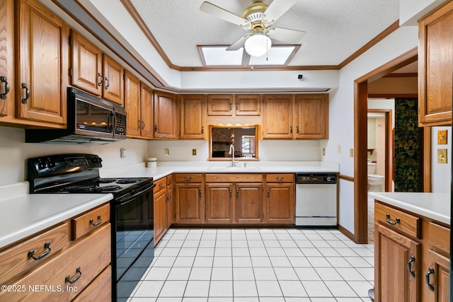 kitchen with a sink, black appliances, brown cabinetry, and light countertops