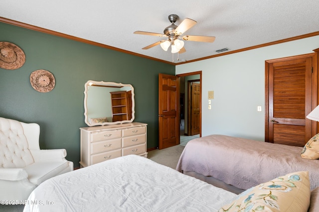 bedroom featuring visible vents, light colored carpet, ceiling fan, ornamental molding, and a textured ceiling