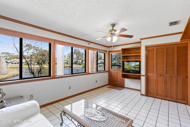 living room featuring visible vents, a ceiling fan, ornamental molding, a textured ceiling, and light tile patterned flooring