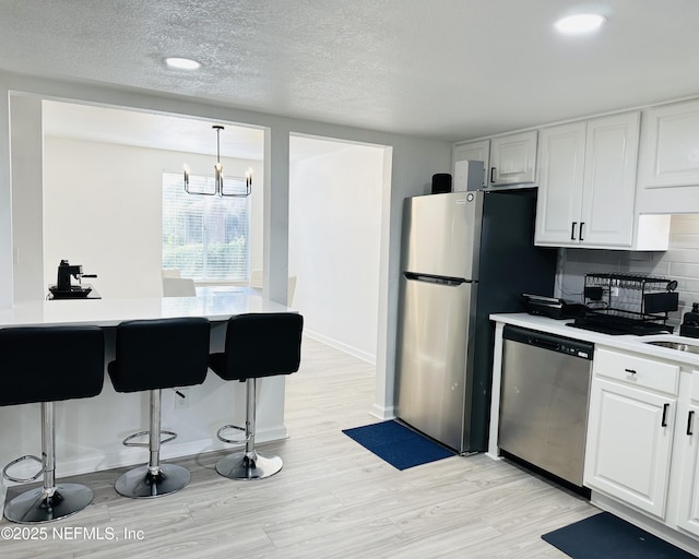 8880 S Old Kings Rd Unit 5, Jacksonville, FL 32257 - kitchen featuring hanging light fixtures, light wood-type flooring, white cabinets, and appliances with stainless steel finishes