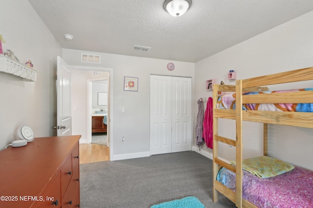 carpeted bedroom with a closet and a textured ceiling