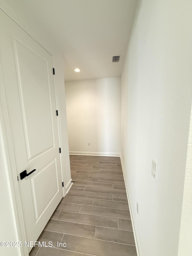 corridor featuring baseboards, recessed lighting, visible vents, and wood tiled floor