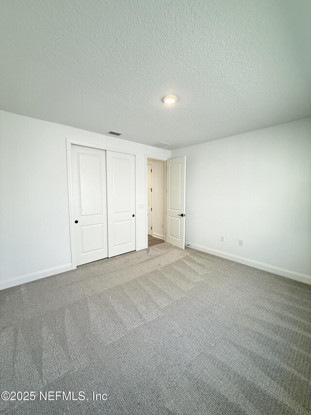 unfurnished bedroom featuring a closet, carpet, and baseboards