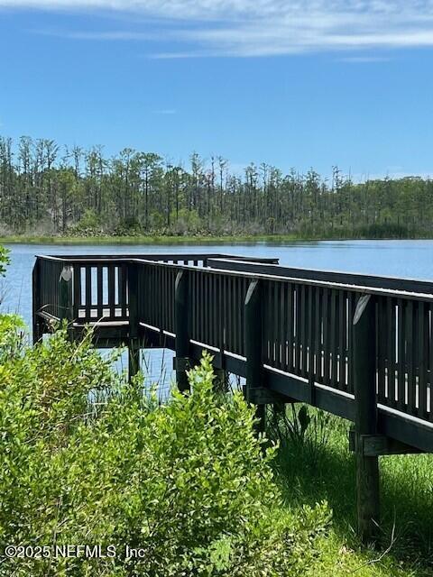 view of dock featuring a water view and a view of trees