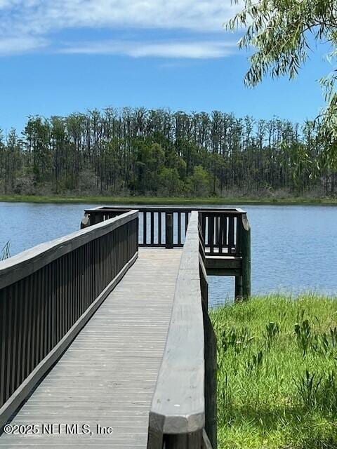 dock area with a water view and a forest view