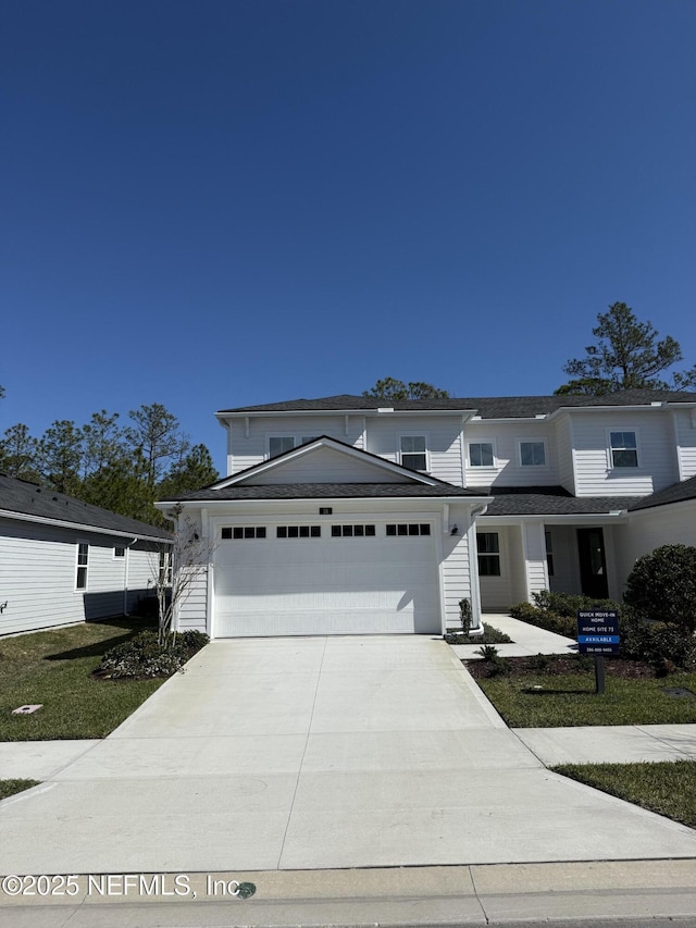 traditional-style house featuring an attached garage and concrete driveway