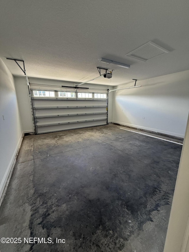 garage featuring a garage door opener and baseboards