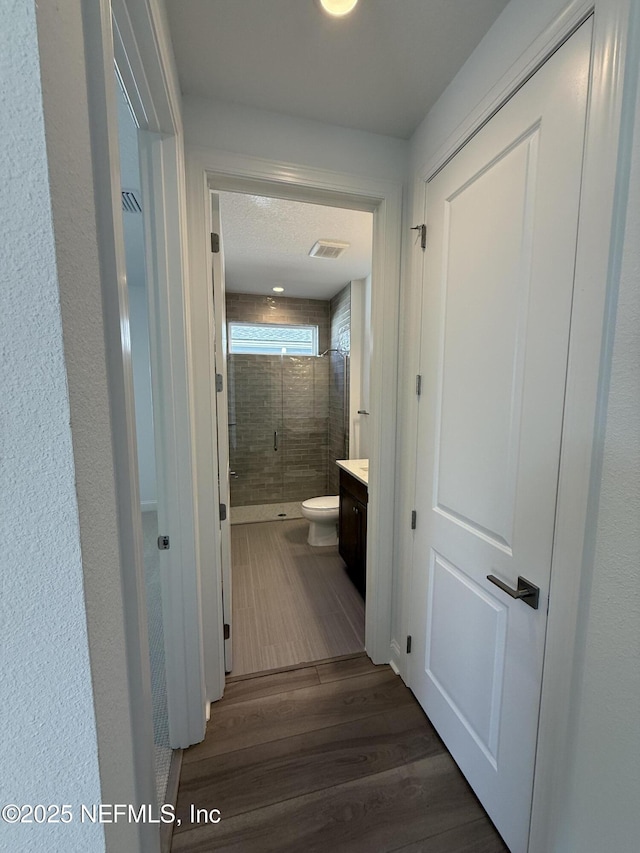 hall featuring dark wood-type flooring and visible vents