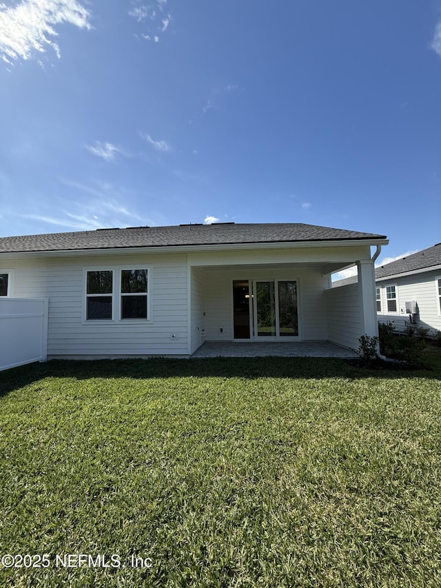 rear view of house featuring a lawn, a patio area, and fence