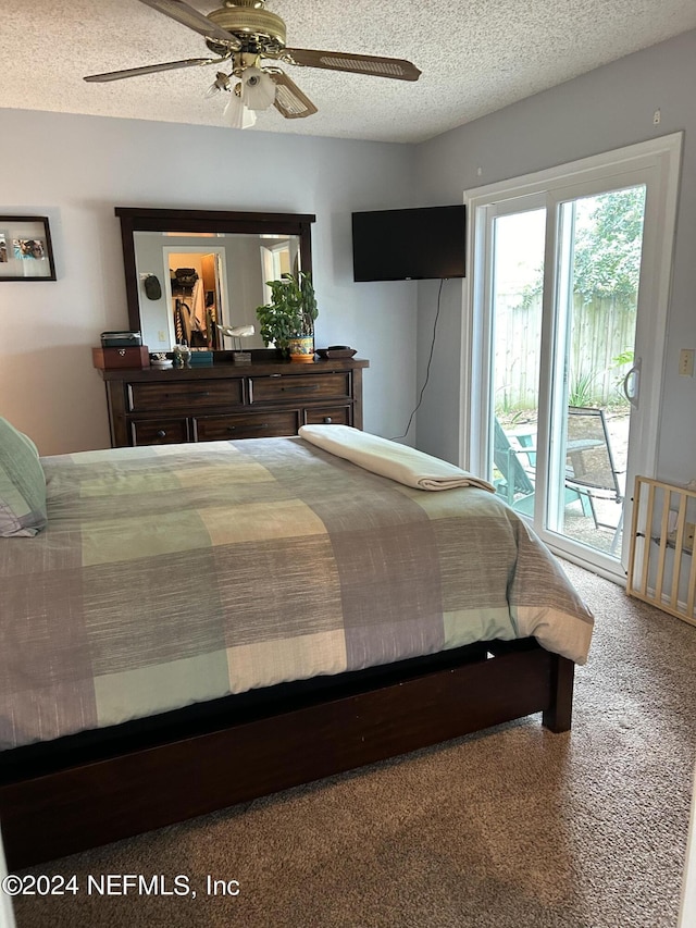 carpeted bedroom with ceiling fan, access to exterior, and a textured ceiling