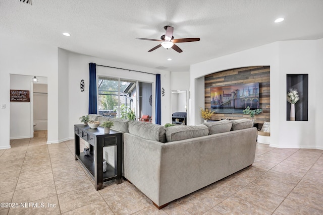 tiled living room featuring ceiling fan and a textured ceiling