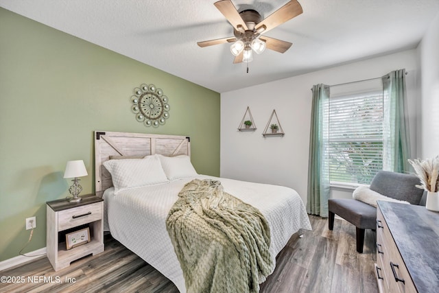 bedroom with ceiling fan, dark hardwood / wood-style floors, and a textured ceiling