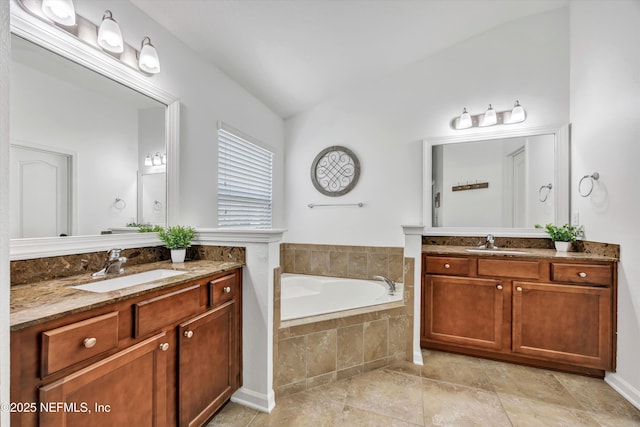 bathroom featuring a relaxing tiled tub, lofted ceiling, and vanity