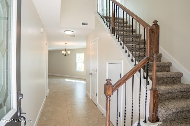 stairway with baseboards, visible vents, and tile patterned floors