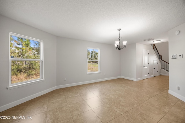 unfurnished room featuring a textured ceiling, visible vents, baseboards, stairs, and an inviting chandelier