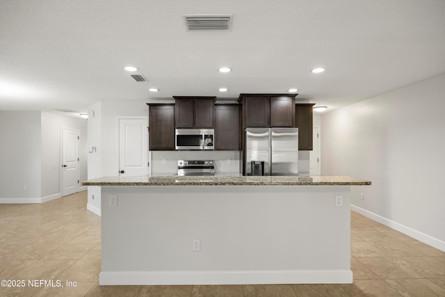 kitchen featuring visible vents, appliances with stainless steel finishes, a kitchen island with sink, dark brown cabinets, and recessed lighting