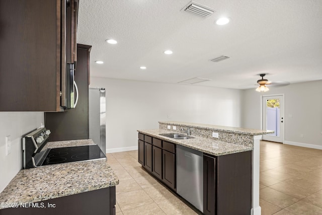 kitchen featuring dark brown cabinets, appliances with stainless steel finishes, a sink, and visible vents