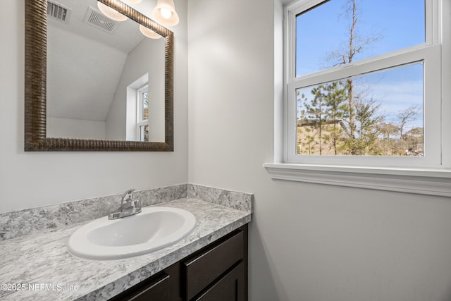 bathroom featuring lofted ceiling, visible vents, and vanity