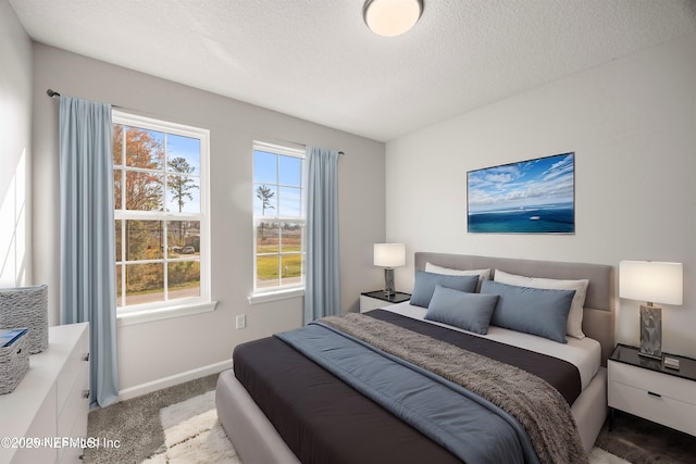 bedroom featuring a textured ceiling, baseboards, and light colored carpet